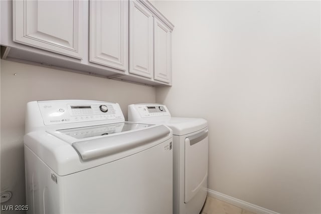 laundry area featuring washer and dryer, cabinet space, and baseboards