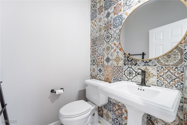 bathroom featuring a sink, toilet, and baseboards