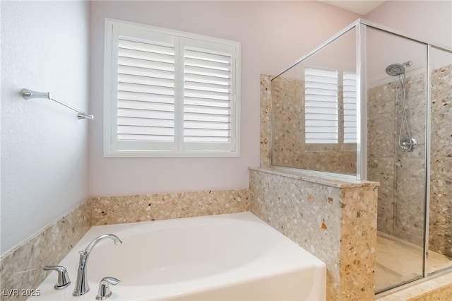 bathroom with a shower stall and a garden tub
