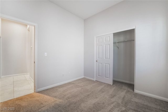 unfurnished bedroom with carpet flooring, a closet, and baseboards