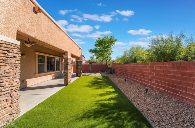fenced backyard featuring ceiling fan and a patio