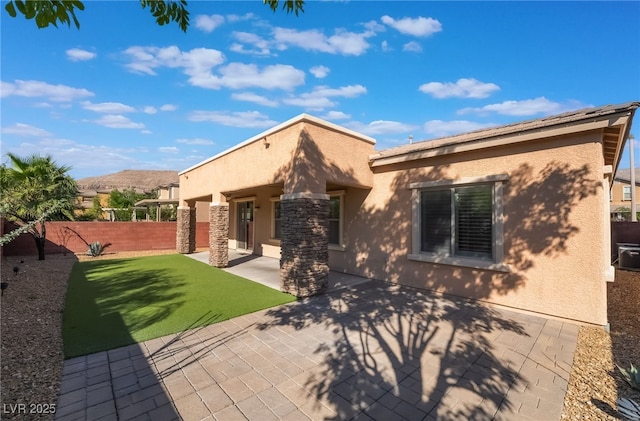 rear view of property featuring stucco siding and a patio area