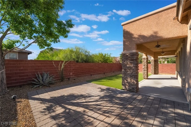 deck with a ceiling fan, a fenced backyard, and a patio