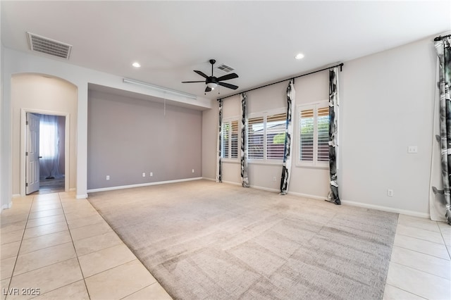 unfurnished room with light tile patterned floors, recessed lighting, a ceiling fan, arched walkways, and baseboards