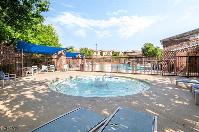 community pool featuring fence and a patio