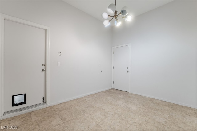 unfurnished room with a chandelier and baseboards