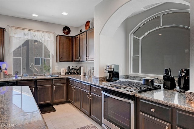 9656 Paraiso Springs St, Las Vegas, NV 89139 - kitchen with stainless steel gas range, a sink, light stone countertops, dark brown cabinets, and recessed lighting