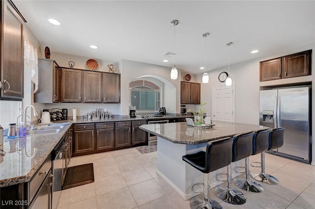 9656 Paraiso Springs St, Las Vegas, NV 89139 - kitchen featuring stainless steel appliances, a sink, dark brown cabinets, dark stone countertops, and recessed lighting