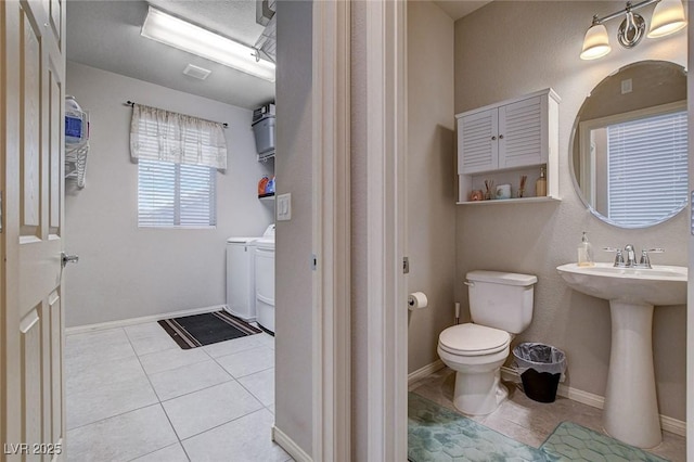 9656 Paraiso Springs St, Las Vegas, NV 89139 - bathroom featuring separate washer and dryer, toilet, tile patterned flooring, and baseboards