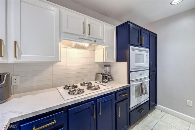 91 E Agate Ave Unit 204, Las Vegas, NV 89123 - kitchen featuring white appliances, under cabinet range hood, decorative backsplash, and blue cabinets