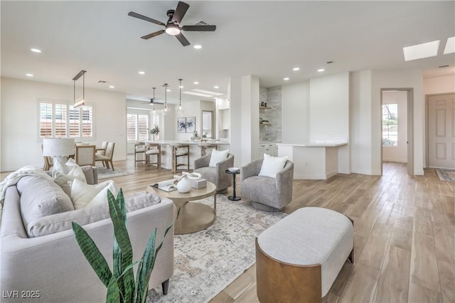 1964 Oliver Springs St, Henderson, NV 89052 - living room with light wood-style floors, recessed lighting, baseboards, ceiling fan, and a skylight