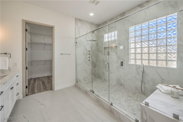 1964 Oliver Springs St, Henderson, NV 89052 - bathroom with a marble finish shower, recessed lighting, a walk in closet, vanity, and baseboards