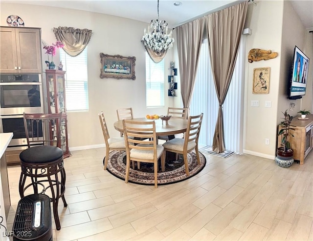 dining area featuring healthy amount of natural light, a chandelier, and baseboards