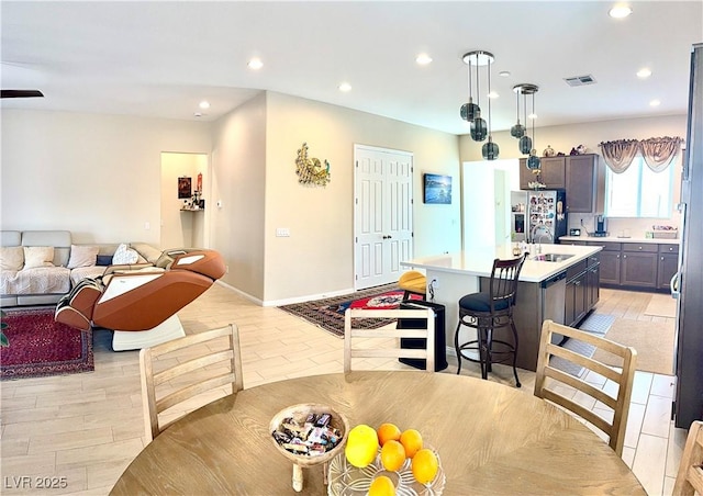 dining room featuring recessed lighting, light wood-style floors, and baseboards