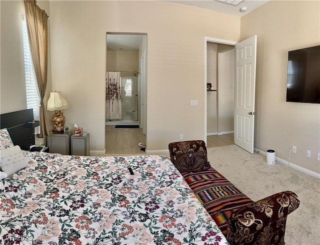 carpeted bedroom featuring baseboards and ensuite bath