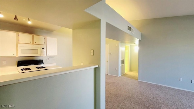 kitchen featuring white appliances, light colored carpet, light countertops, and baseboards