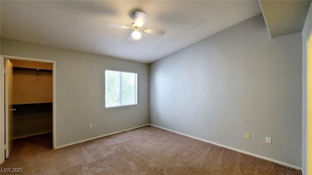 unfurnished bedroom with a spacious closet, carpet, and baseboards