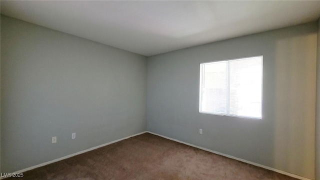 spare room with carpet and baseboards