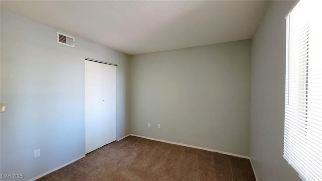 unfurnished bedroom with carpet flooring, a closet, and baseboards