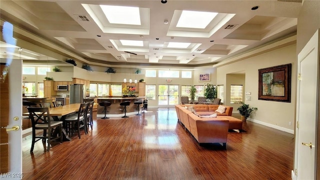 office area with plenty of natural light, dark wood-style floors, baseboards, a high ceiling, and coffered ceiling