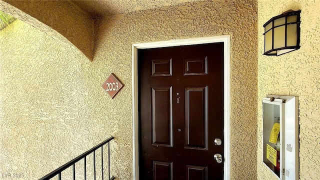 view of exterior entry featuring stucco siding