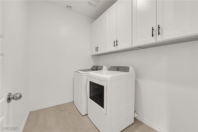 washroom with separate washer and dryer, cabinet space, and baseboards