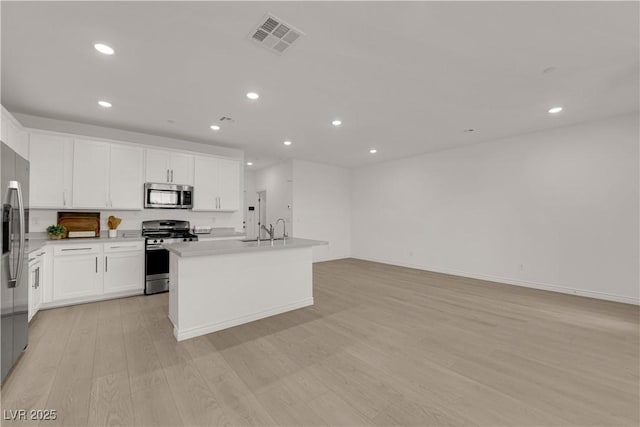kitchen with stainless steel appliances, light wood-style floors, a sink, recessed lighting, and white cabinets