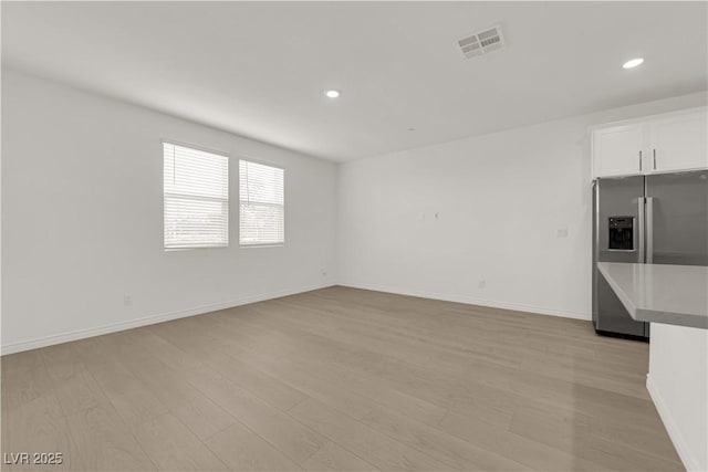 unfurnished living room with light wood-style flooring, recessed lighting, and baseboards