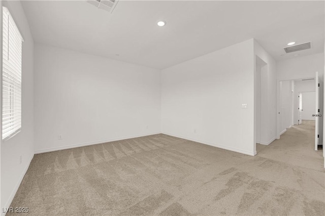 empty room featuring carpet flooring, baseboards, recessed lighting, and plenty of natural light