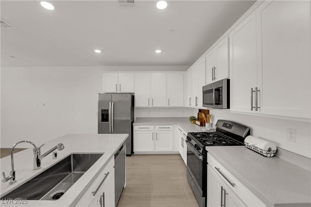 334 Laurel Peak Dr, Henderson, NV 89015 - kitchen with appliances with stainless steel finishes, a sink, white cabinets, recessed lighting, and light countertops