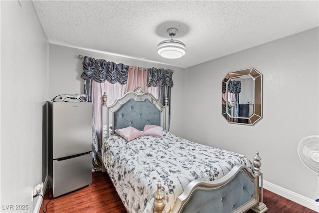 bedroom featuring wood finished floors, a textured ceiling, baseboards, and freestanding refrigerator