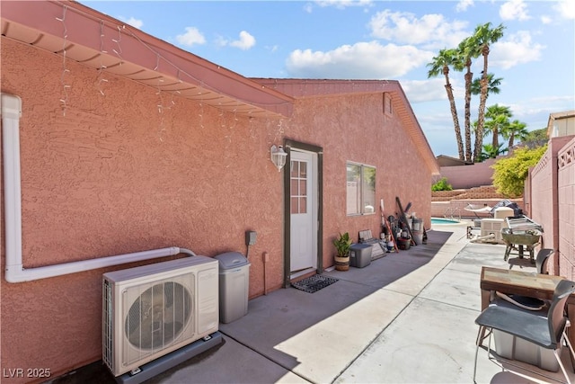 view of home's exterior with ac unit, stucco siding, a patio, and a fenced backyard