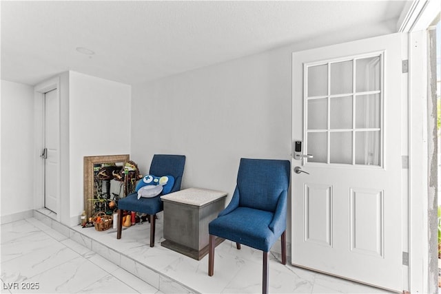 living area with marble finish floors and baseboards