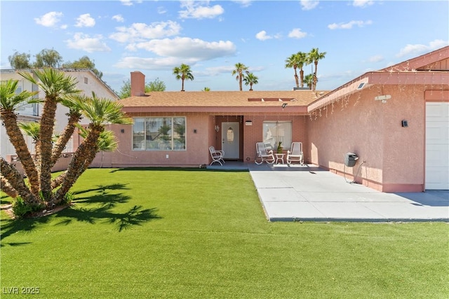rear view of property featuring a patio, a yard, and stucco siding