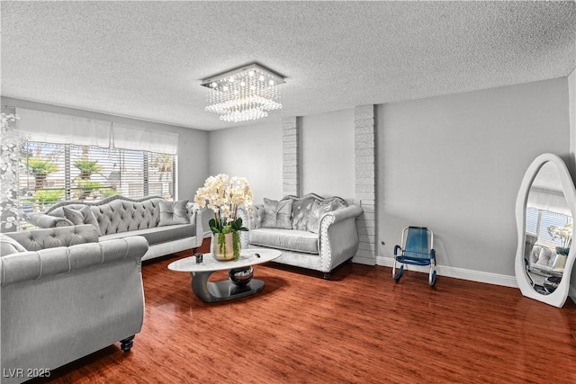 living room featuring a chandelier, a textured ceiling, plenty of natural light, and wood finished floors