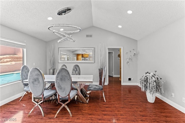 dining area with a textured ceiling, vaulted ceiling, wood finished floors, baseboards, and a chandelier