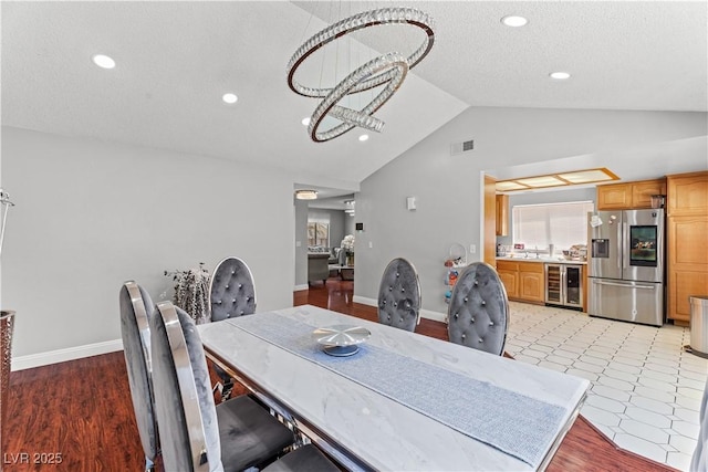 dining space with wine cooler, lofted ceiling, recessed lighting, light wood-type flooring, and baseboards