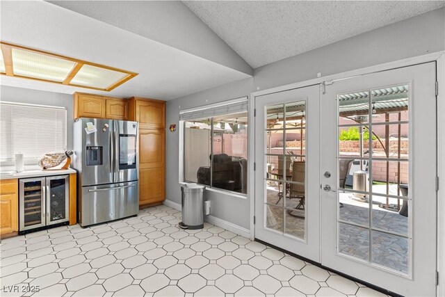 kitchen with stainless steel fridge with ice dispenser, beverage cooler, light floors, vaulted ceiling, and light countertops