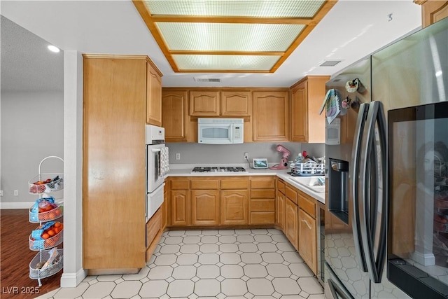 kitchen featuring stainless steel appliances, a warming drawer, light countertops, light flooring, and recessed lighting
