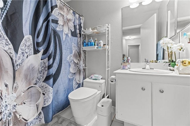 bathroom featuring tile patterned flooring, toilet, and vanity