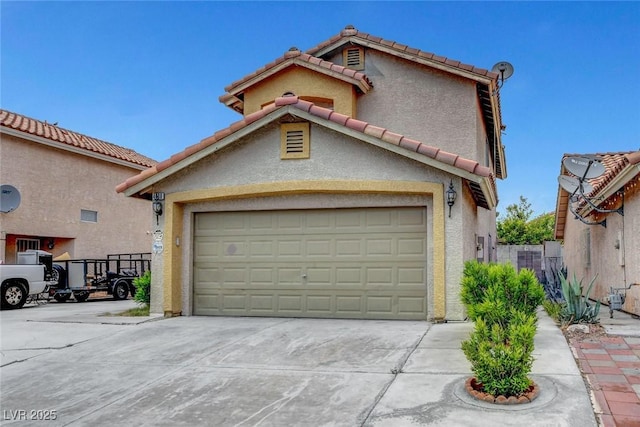 view of front of property featuring concrete driveway, a tiled roof, and stucco siding