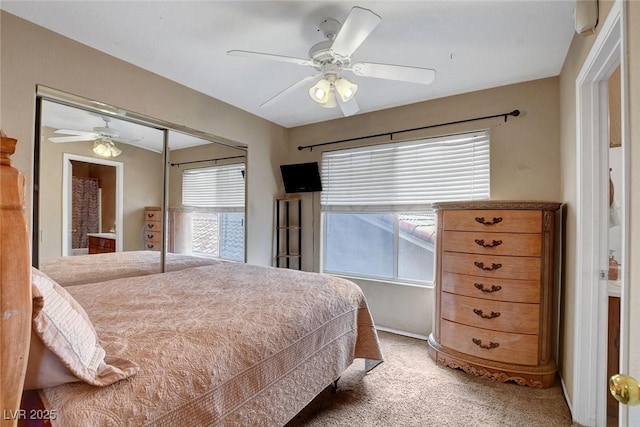 bedroom featuring light carpet, a ceiling fan, and a closet