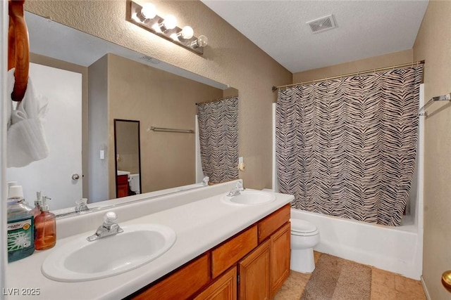 full bathroom with shower / tub combo with curtain, double vanity, toilet, and a textured ceiling