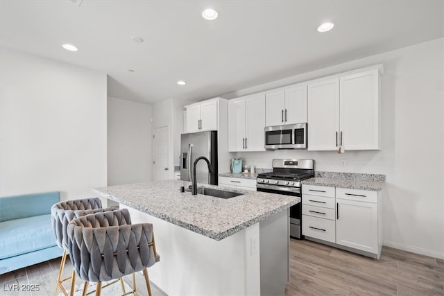 4526 Cloudrest Peak St, North Las Vegas, NV 89031 - kitchen featuring appliances with stainless steel finishes, a sink, an island with sink, light wood finished floors, and recessed lighting