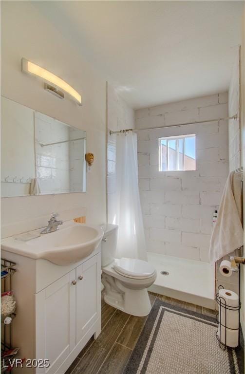 533 Date St, Boulder City, NV 89005 - bathroom featuring tiled shower, toilet, wood finished floors, and vanity
