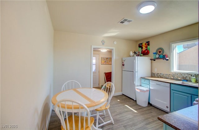 533 Date St, Boulder City, NV 89005 - kitchen featuring white appliances, light wood-type flooring, decorative backsplash, a sink, and blue cabinets