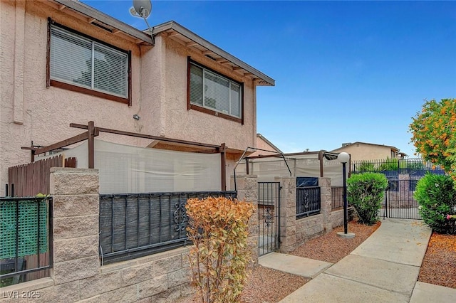 4339 Spencer St Unit 15, Las Vegas, NV 89119 - view of front of home with stucco siding, fence, and a gate