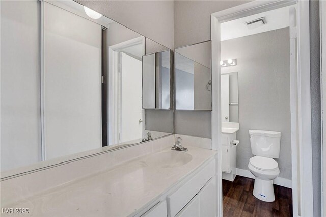 4339 Spencer St Unit 15, Las Vegas, NV 89119 - bathroom with wood finished floors, toilet, vanity, and baseboards