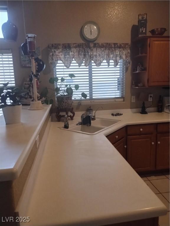 kitchen featuring a sink, light countertops, light tile patterned flooring, and open shelves