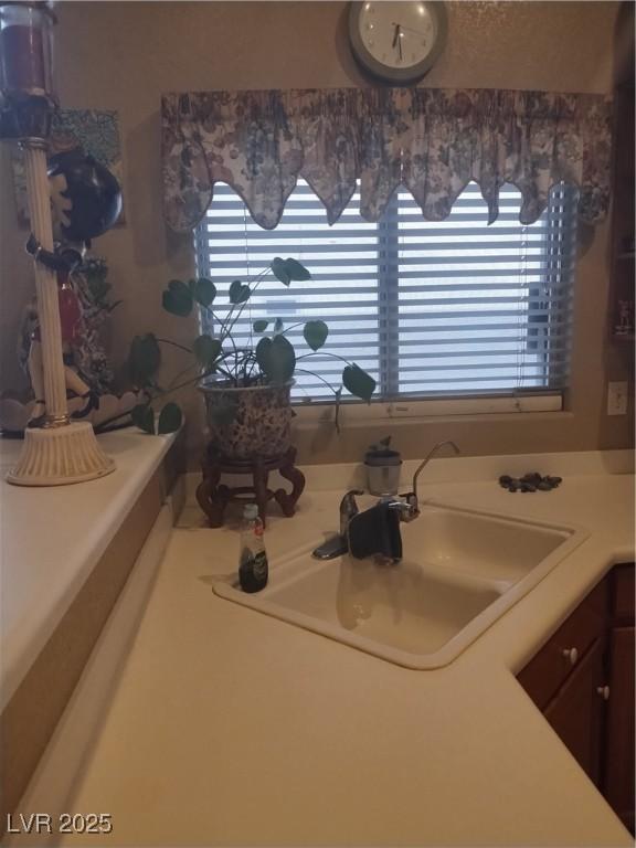 kitchen view of a sink and light countertops